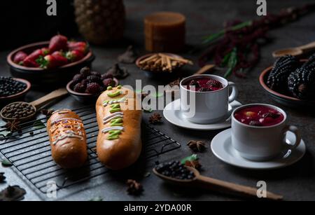 Guaguas de Pan mit Tassen Colada Morada, traditionelles ecuadorianisches Essen für den Tag der Toten, umgeben von den Zutaten, um die Colada wieder zu kochen Stockfoto