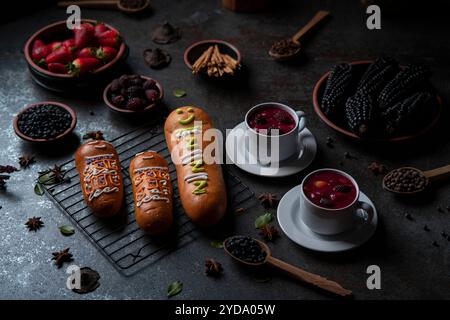 Guaguas de Pan mit Tassen Colada Morada, traditionelles ecuadorianisches Essen für den Tag der Toten, umgeben von den Zutaten, um die Colada wieder zu kochen Stockfoto