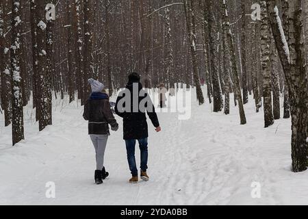 Ein paar spazieren durch eine Gasse in einem Park nach einem starken Schneesturm. Winterspaziergang Stockfoto