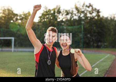 Porträt glücklicher Gewinner mit Medaillen im Stadion Stockfoto