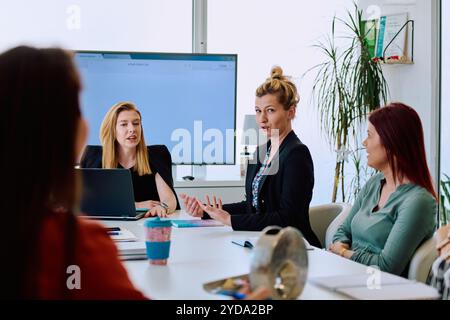 Diverse Geschäftsteams diskutieren Projekte in einem modernen Glasbüro. Stockfoto