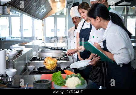 Kochkurs-Atmosphäre, besteht darin, eng mit einem Koch zusammenzuarbeiten und von erfahrenen Köchen in anerkannten Institutionen zu lernen. Stockfoto