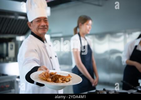 Kochkurs-Atmosphäre, besteht darin, eng mit einem Koch zusammenzuarbeiten und von erfahrenen Köchen in anerkannten Institutionen zu lernen. Stockfoto