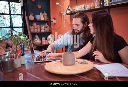 Zwei junge Unternehmer, die ein Töpfergeschäft besitzen. Wir besprechen den Behälter, den der Kunde Formen möchte. Zur Dekoration des h Stockfoto