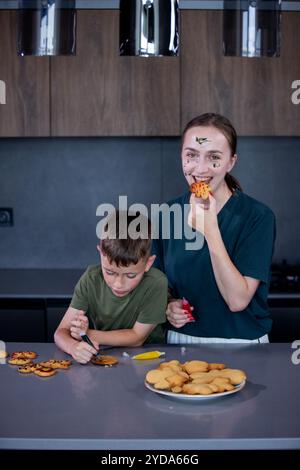 Mutter und Sohn essen frisch gebackenen Lebkuchen zusammen. Stockfoto