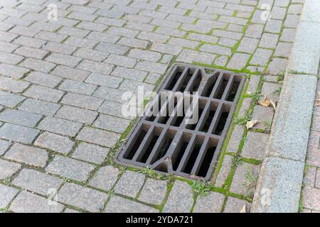 Straßenrastgitter Drainage Regenkanalisation Mannloch Sturm Hochwasser Kanalisation Kanalisation Abwasserkanal Abfluss Stockfoto