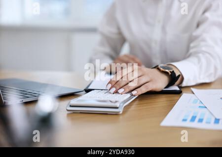 Banker benutzt Taschenrechner am Holztisch im Büro, Nahaufnahme Stockfoto