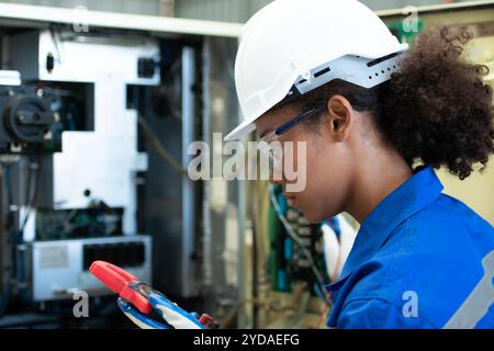 Erfahrene Elektroingenieurin die elektrische Anlage der elektrischen Steuerung des Schweißroboters wird überprüft Stockfoto