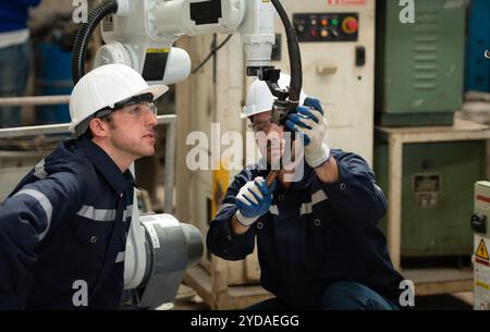 Die beiden Ingenieure prüfen die Funktion von Schweißrobotern. Stockfoto