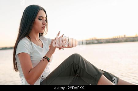 Frau überprüft ihre körperliche Aktivität auf Smartwatch. Junge Sportlerin, die während des Trainings auf Aktivitätstracker blickt. Stockfoto