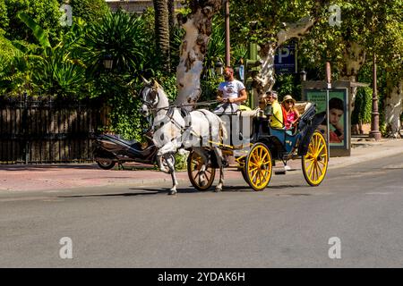 Touristen in einer Pferdekutschfahrt in der Nähe der Kathedrale von Sevilla, Sevilla, Andalusien, Spanien. Stockfoto