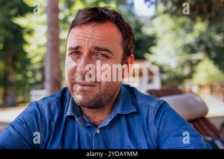 Ein Nahporträt im Profil eines attraktiven Mannes in einem Jeanshemd. Stockfoto