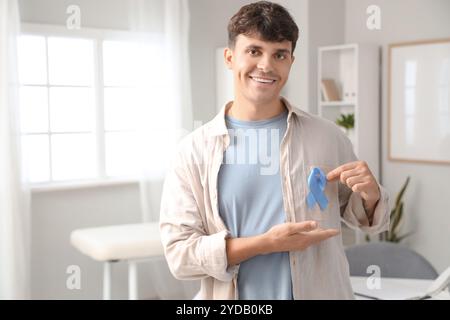 Junger Mann mit blauem Band in der Klinik. Prostatakarzinom-Bewusstseinskonzept Stockfoto