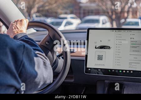 Salt Lake City, UT, US-19. März 2024: Fahrer und Innenraum eines Tesla Elektrofahrzeugs mit großem Computerdisplay. Stockfoto