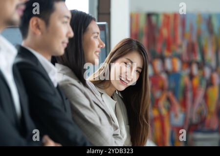 Die junge asiatische Jungfrau schloss sich der Gruppe junger Unternehmer an, die drei Senioren im Team waren. Stockfoto