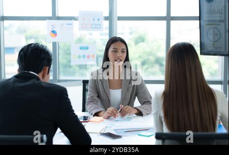 Eine Gruppe junger asiatischer Unternehmer. Das oberste Management trifft sich, um die Anlagedaten des Teams in einem Besprechungsraum zu prüfen Stockfoto