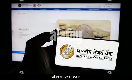 In dieser Abbildung hält eine Person ein Smartphone mit dem Logo der indischen Zentralbank Reserve Bank of India (RBI) vor der Website. Stockfoto