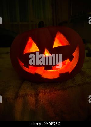 Gruseliger Halloween-Kürbis mit geschnitztem Gesicht, das im Dunkeln leuchtet Stockfoto