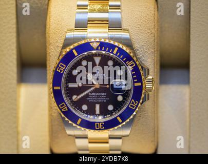 Eine auffällige Rolex-Uhr zeigt eine Mischung aus Blau, Schwarz, Gold und Silber und verkörpert Luxus und Präzision. Stockfoto