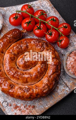 Köstliche hausgemachte Wurst in Form einer Spirale gebacken auf dem Grill mit Salz, Gewürzen Stockfoto