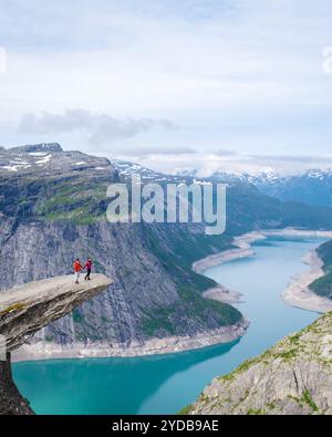 Paare bewundern Norwegian Fjord View, Männer und Frauen auf dem Gipfel eines Berges Trolltunga, Norwegen Stockfoto