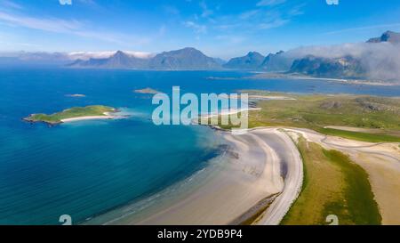 Ein Blick aus der Vogelperspektive auf eine atemberaubende Küstenlandschaft in Norwegen, mit einem langen Sandstrand, der sich um eine kleine Insel dreht und von grünen Hügeln umgeben ist Stockfoto