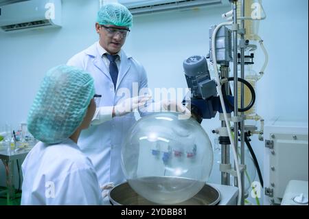 Wissenschaftler und Assistenten sind im Maschinenraum, um Öl und Cannabissamen zu extrahieren. Überprüfung des Cannabisölextraktors vor St. Stockfoto