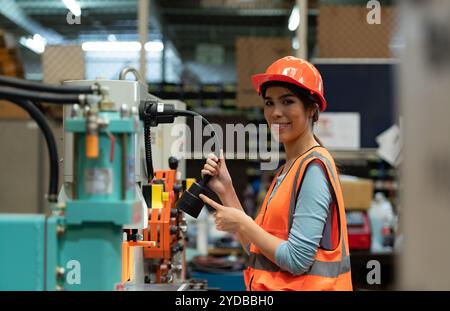 Porträt einer asiatischen Frau mit großen Maschinen, die in schweren Industrieanlagen eingesetzt werden. Stockfoto