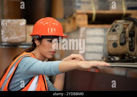 Porträt einer asiatischen Frau mit großen Maschinen, die in schweren Industrieanlagen eingesetzt werden. Stockfoto