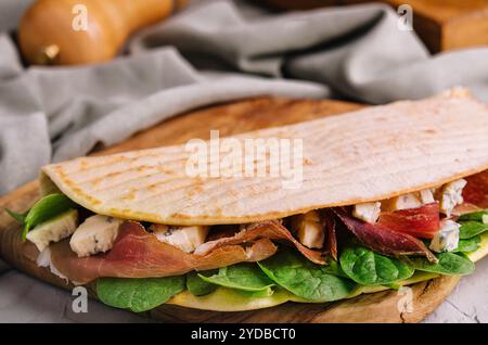 Piadina: Klassisches italienisches Tortilla-Brot mit Schinken, Basilikum und Dor Blue Stockfoto