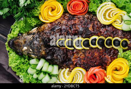 Gebackener Karpfen mit Gemüse in einer Auflaufform auf dem Tisch Stockfoto