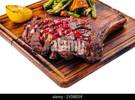 Gegrilltes Schweinefleisch in Scheiben mit Granatapfelkernen und Spargel Stockfoto