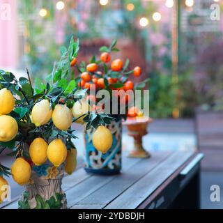 Zweig mit Zitronen, Mandarinen in Keramikvase auf dem Tisch. Traditionelles Muster, Sizilien, Italien. Obst und Einrichtung. Stockfoto