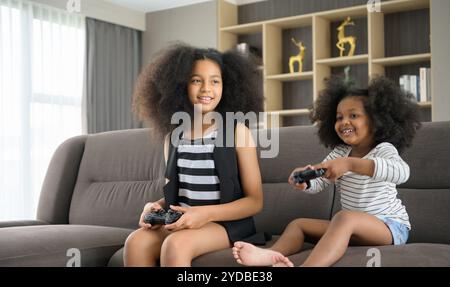 Zwei Brüder einer asiatisch-afroamerikanischen Familie. Entspannen Sie sich und spielen Sie Online-Spiele im Wohnzimmer des Hauses. Stockfoto