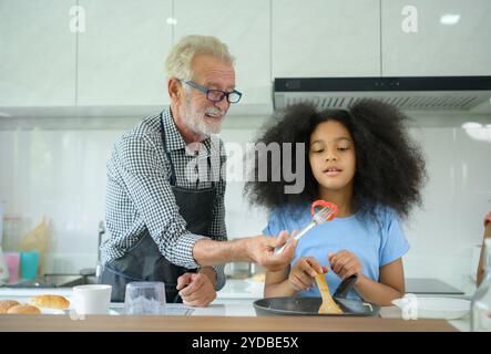 Familienurlaub mit Großvater und Enkelkindern. Zusammen zu kochen für den Großvater der Familie, lehrt Coo Stockfoto