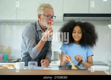 Familienurlaub mit Großvater und Enkelkindern. Zusammen zu kochen für den Großvater der Familie, lehrt Coo Stockfoto