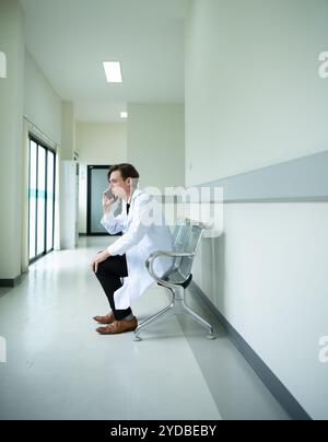 Der Arzt benutzt das Telefon, um die Aufgaben zu sehen, die für den Tag verantwortlich sein werden Stockfoto