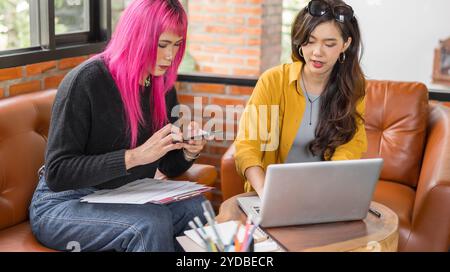 LGBTQ+ Transgender Mann schöne authentische SpecialistÂ mit rosa Haaren und nicht-binären Trans, die zusammen arbeiten Design in cr Stockfoto