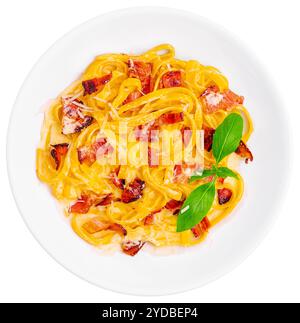 Pasta mit Speck und Basilikum auf weißer Platte Stockfoto