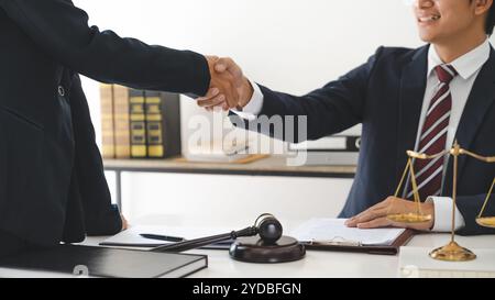 Anwalt, der Hand schüttelt und Kunde unterzeichnet Vertragsvereinbarung. In Anwaltskanzlei. Handshake für Geschäftstreffen. Â Stockfoto