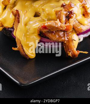 Schwarzer Burger mit Schweinefleisch auf Schwarz Stockfoto