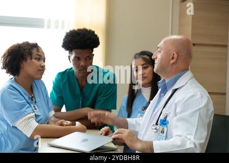 Ein Medizinprofessor berät die praktizierenden Medizinstudenten bei Patientenuntersuchungen Stockfoto