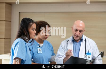 Ein Medizinprofessor berät die praktizierenden Medizinstudenten bei Patientenuntersuchungen Stockfoto