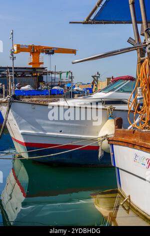 Jaffa, Israel - 10. Mai 2024: Blick auf Fischerboote und einen Kran im historischen Hafen von Jaffa, heute Teil von Tel-Aviv-Yafo, Israel Stockfoto