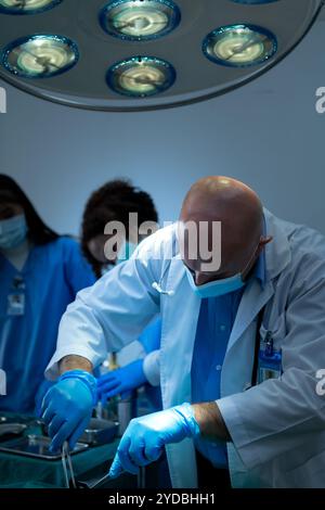Ein Medizinprofessor unterrichtet Chirurgie an Medizinstudenten, die arbeiten Stockfoto