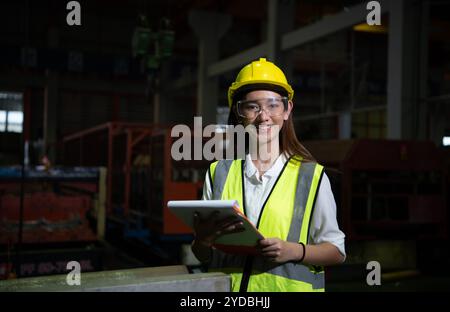 Die weibliche Führungskraft arbeitet im Auditbereich. Sie arbeitet daran, die Qualität der Arbeit in schweren Industrieanlagen zu überprüfen Stockfoto