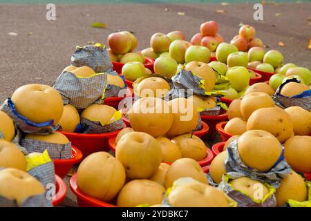 Ulsan, Südkorea - 5. Oktober 2024: Frische Äpfel und koreanische Birnen werden in roten Körben zum Verkauf am Straßenrand in der Nähe des Taehwa River Nat ausgestellt Stockfoto