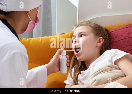 Kinderarzt Arzt mit medizinischen Spray für junge Mädchen zu Hause, Halsschmerzen Stockfoto