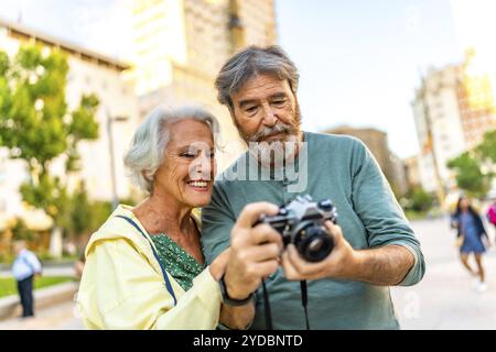 Senior Modern caucasian Pärchen, die sich die Bilder auf einem Kamerabildschirm anschauen, während sie eine Stadt besuchen Stockfoto