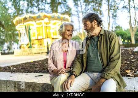 Senior Pärchen sitzen und plaudern in der Stadt neben dem Nachtfest Stockfoto